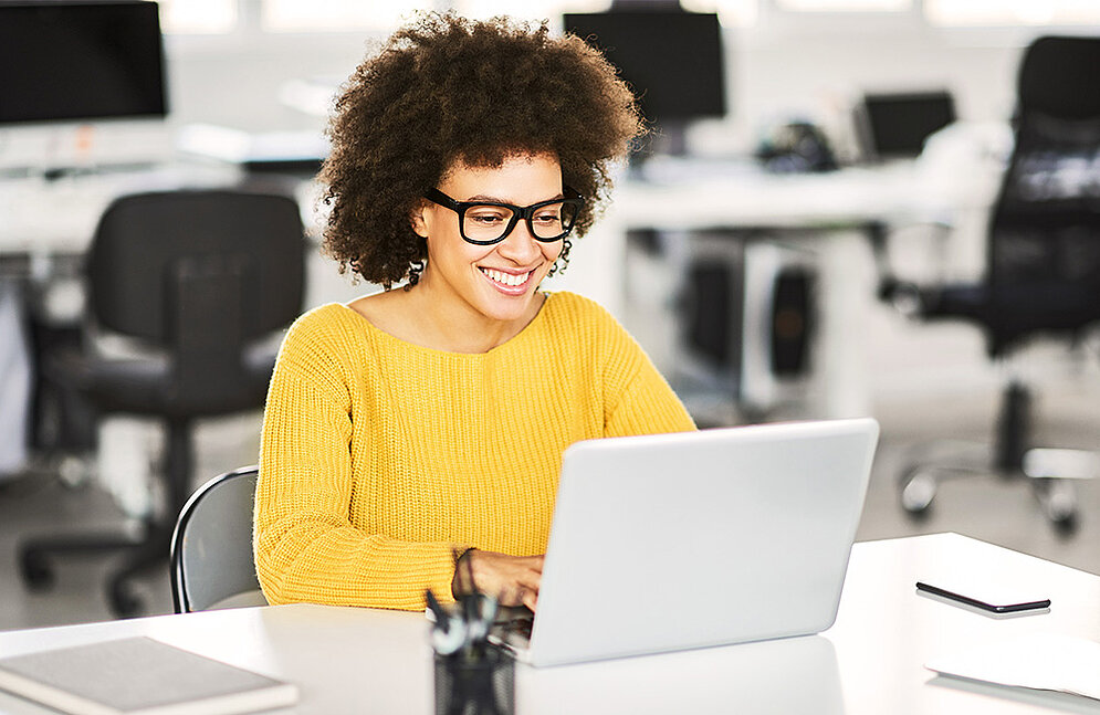 Unsere Kurse sind optimal auf den Lernerfolg Ihrer Mitarbeitenden ausgerichtet. Frau lernt mit Freude am Laptop